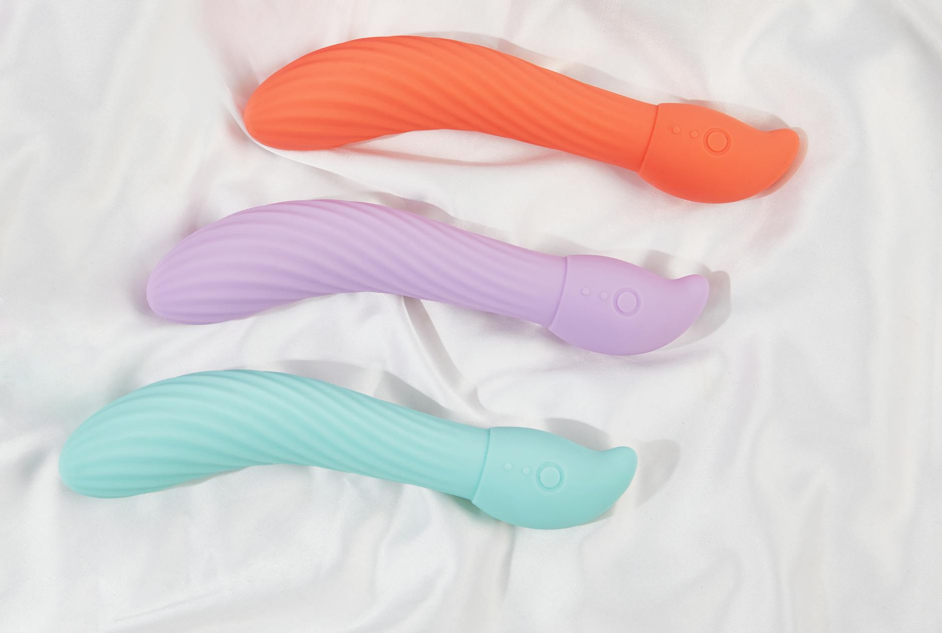 Three colorful lemon vibrators and traditional vibrators arranged on white fabric showing texture differences.