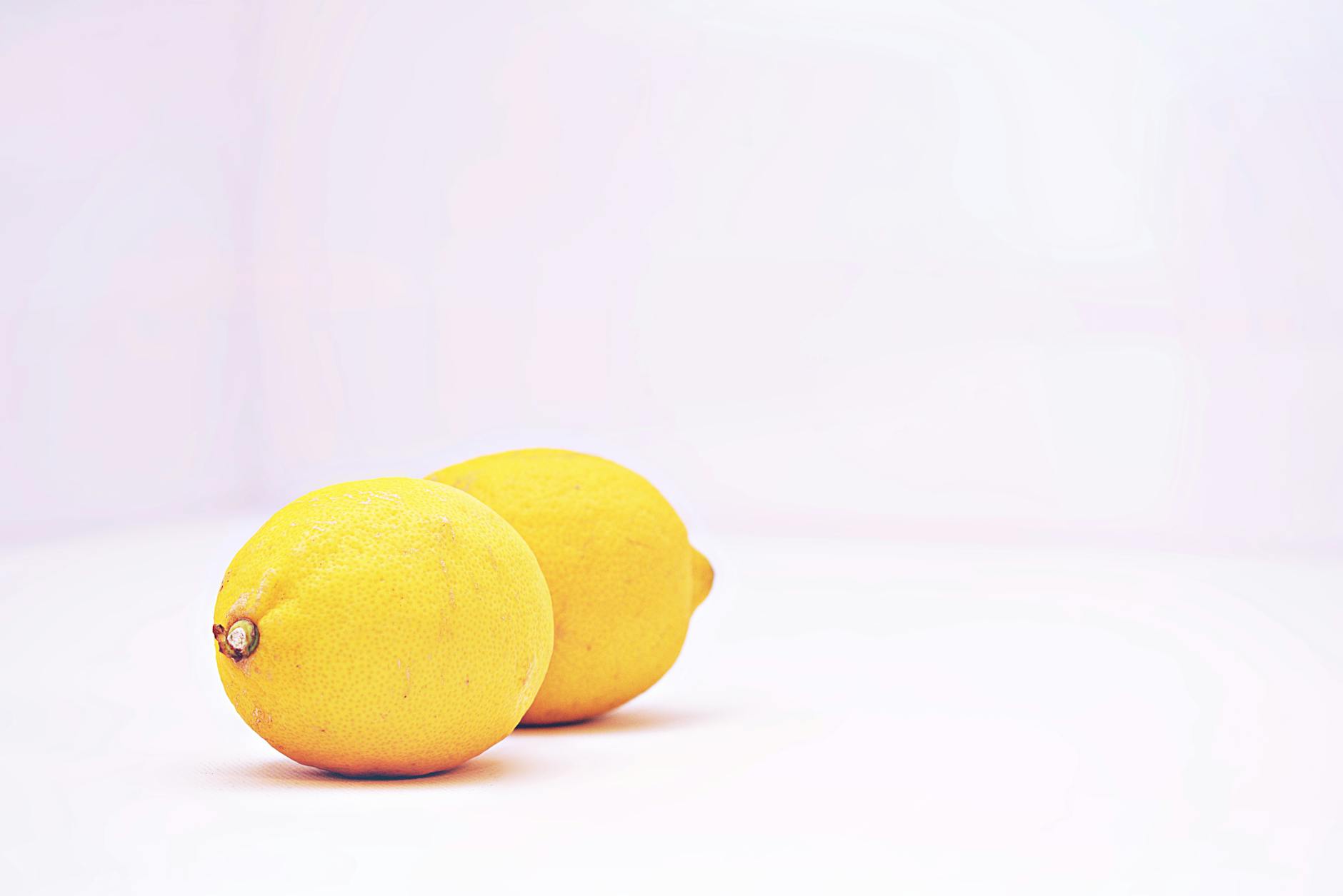 Two bright yellow lemons on a white background, symbolizing the lemon vibrator's distinctive shape
