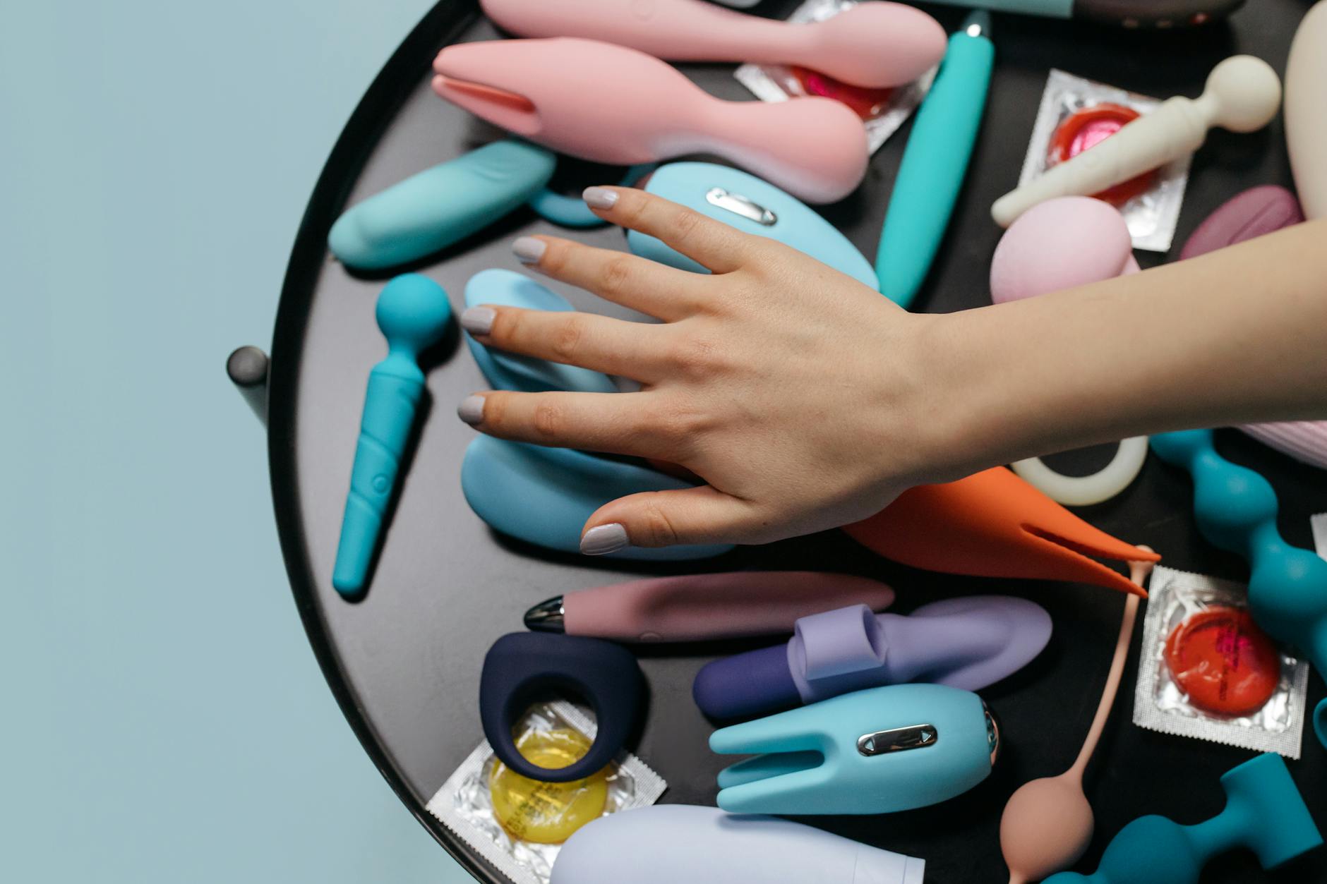 Hand exploring different vibrator styles and clitoral stimulation options