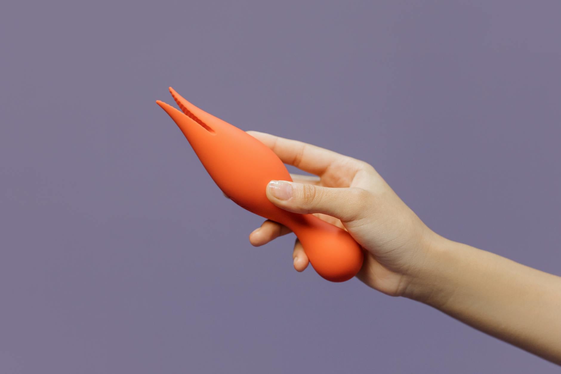 Hands holding a sleek blue vibrator against a purple background, symbolizing intimate pleasure and self-care